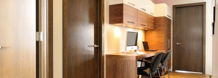 Contemporary custom-designed desk installed against a wall and with various storage spaces.