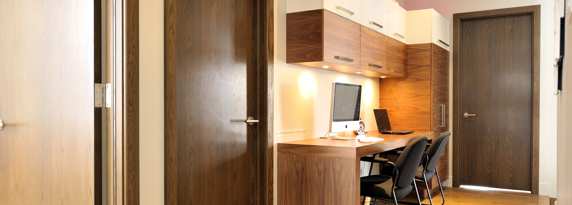 Contemporary custom-designed desk installed against a wall and with various storage spaces.