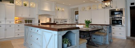 Rustic Kitchen with a solid wood central island and white cabinets.