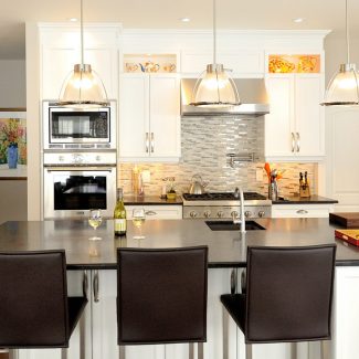 White kitchen with built-in cabinets and dark countertops in a bright room.