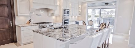 White kitchen with built-in cabinets and spacious central island.