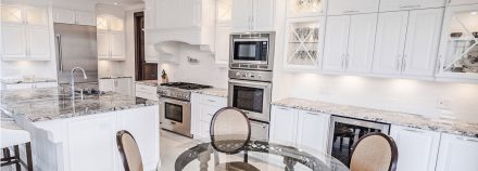 Classic Kitchen with white cabinets, stone countertops, and a ceramic backsplash.