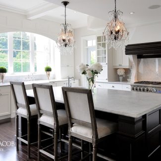 White kitchen with central island and built-in cabinets.