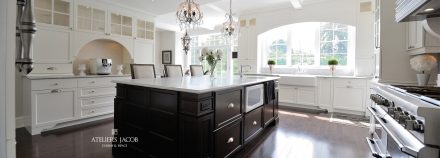 Spacious white kitchen with central island and integrated storage.