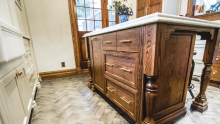 Fitted kitchen with wooden central island and light-colored worktop.