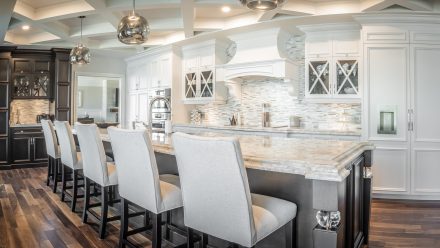 Classically styled white Kitchen with stone countertops and wooden cabinets.