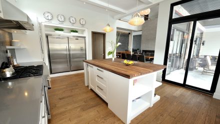 Spacious kitchen with dark countertops, soft lighting, and integrated appliances.