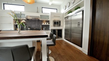 White kitchen with high-end appliances and central island.