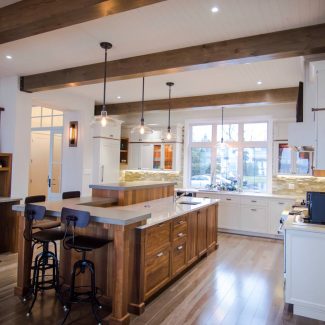 A designer kitchen with a wooden island and dining area.