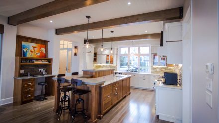 A designer kitchen with a wooden island and dining area.