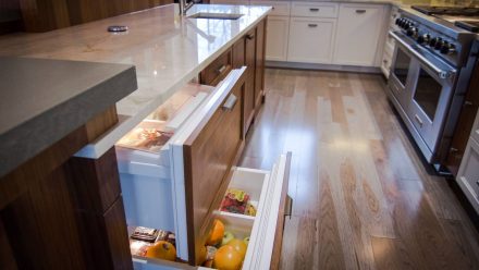 Spacious kitchen with integrated lighting and white cabinets.