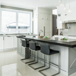 Spacious streamlined kitchen with central island and light-colored countertop.