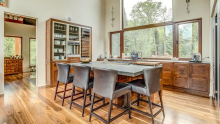 Kitchen with central island, wooden cabinets, and dark worktop.