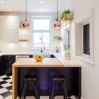 Spacious kitchen with central island and warm lighting, designed for Geneviève Everell.