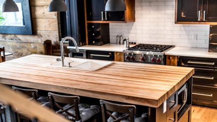 Kitchen with dimmed lighting and wooden countertops in a spacious environment.