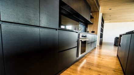 Minimalist Kitchen with worktop and central island in an elegant arrangement of neutral tones.