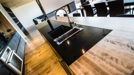 Contemporary dark Kitchen with central island and integrated appliances.