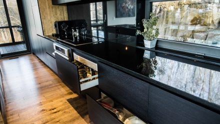 Spacious kitchen with black cabinets, dark countertops, and functional storage.