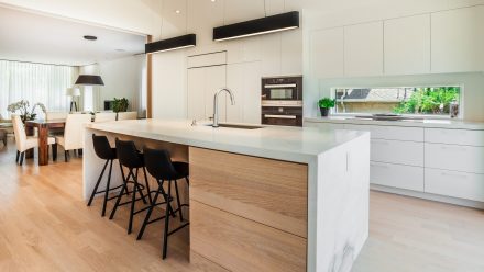 A spacious kitchen with white cabinets and light countertops.