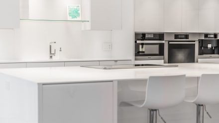 Design kitchen with white worktop and white backsplash.