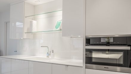 Contemporary Kitchen with central island and glass shelves.