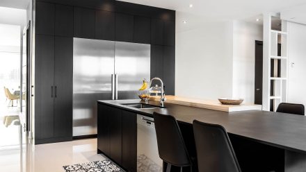 Modern equipped kitchen with dark worktop and built-in appliances.