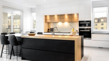 A contemporary kitchen with central island and dining area.