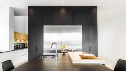 Cuisine blanche et noire avec îlot central dans un design moderne.