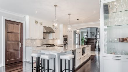 Spacious kitchen with central island and elegant white cabinets.