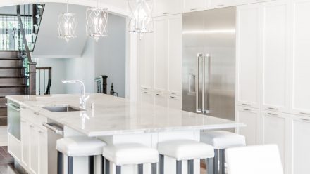 Elegant Kitchen with white cabinets and light stone countertops.