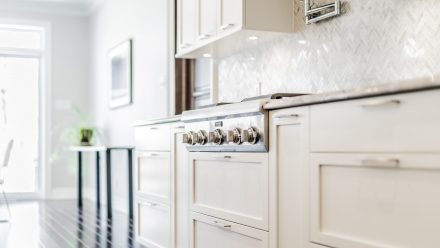 Spacious kitchen with white cabinets and elegant , modern style LED lighting under the cabinets.