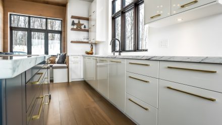 Spacious kitchen with central island and white cabinets.