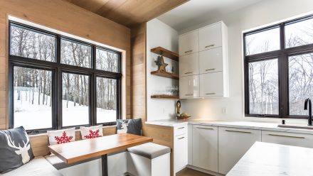 Kitchen fitted with white cabinets, open shelves, and central island.