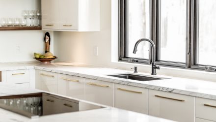 Spacious and elegant kitchen with a light colored countertop and central island.