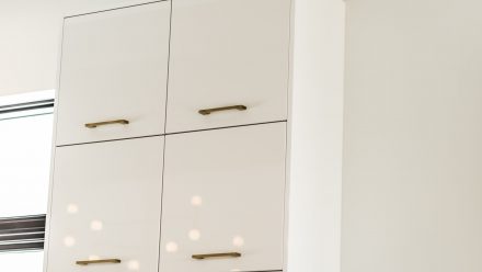 White kitchen with hanging cabinets.