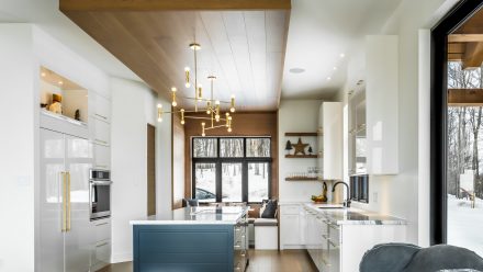 Kitchen with central island and neutral colored cabinets in a timeless style.