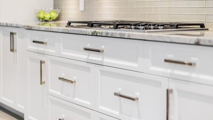 kitchen fitted with white cabinets and central island.