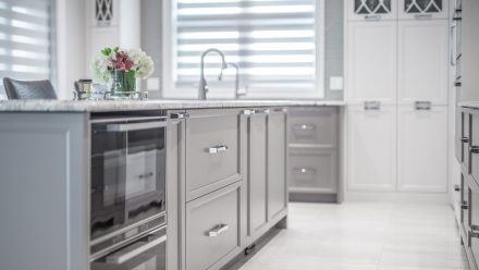 Elegant white kitchen with central island and built-in cabinets.