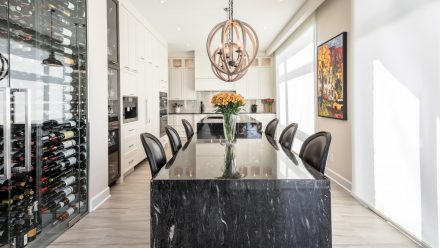 Spacious and bright kitchen with white cabinets, central island, and dining area.