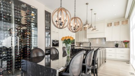 White kitchen with central island and full wall of built-in cabinets.