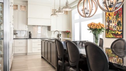 Transitional kitchen with white cabinets, central island, and dining area.