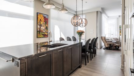 Elegant Kitchen with white built-in cabinets and a dark central island.