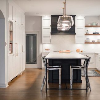 Spacious white and grey kitchen with island and dining area.