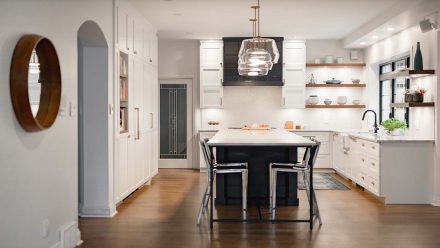 Spacious white and grey kitchen with island and dining area.