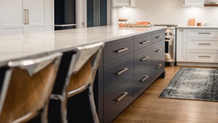 Gray and white kitchen with spacious central island and dining area.