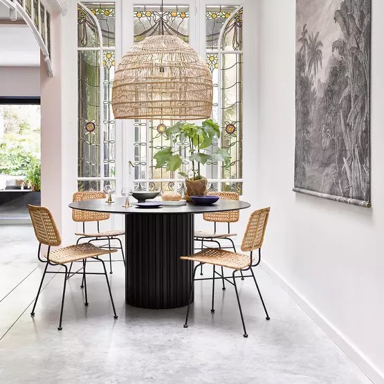 Black massive antique style table paired with modern chairs
