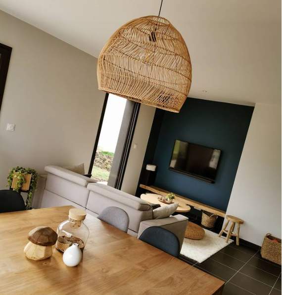 A pretty rattan lamp hangs above a wooden dining table