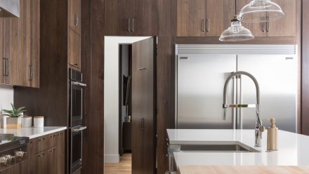 Contemporary wooden kitchen with island and built-in appliances.