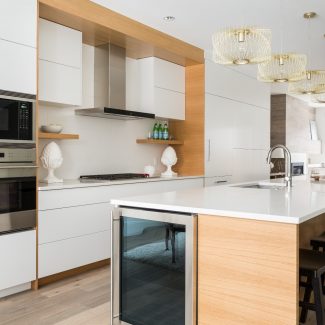 Modern Kitchen with white cabinets, central island, and white backsplash.