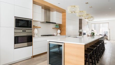 Modern Kitchen with white cabinets, central island, and white backsplash.